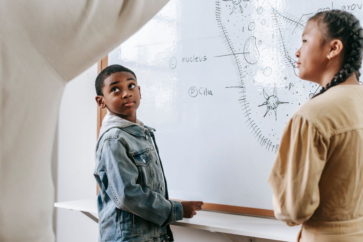 School pupils presenting and explaining science work while their teacher listens